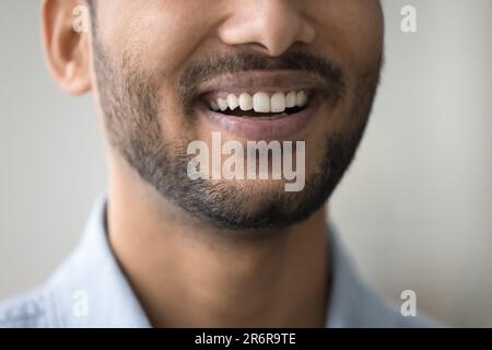 Ein zahniges Lächeln eines glücklichen, dunkelhäutigen Mannes mit weißen Zähnen Stockfoto