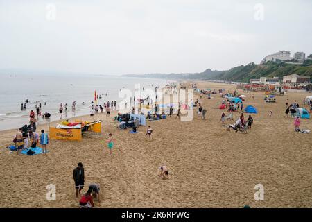 Strandbesucher an einem bedeckten Bournemouth Beach in Dorset. Das MET Office hat Leitlinien herausgegeben, dass die meisten von Großbritannien die Hitzewellen-Kriterien nächste Woche erfüllen werden, und eine gelbe Warnung für heißes Wetter wurde von der UK Health Security Agency (UKHSA) herausgegeben. Foto: Sonntag, 11. Juni 2023. Stockfoto