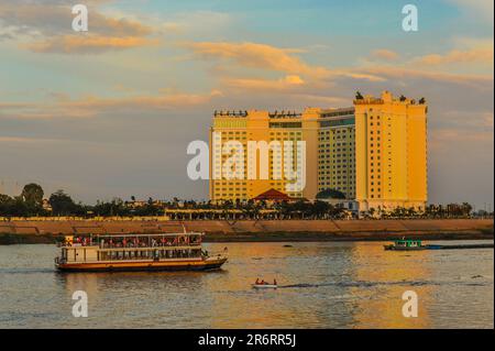 Ein Dinner-Kreuzfahrtschiff. Flussschifffahrt auf dem Tonle SAP River in der Dämmerung, das Sokha Hotel im Hintergrund, Phnom Penh, Kambodscha. Kredit: Kraig lieb Stockfoto