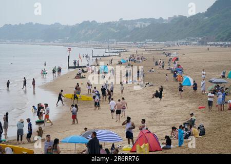 Strandbesucher an einem bedeckten Bournemouth Beach in Dorset. Das MET Office hat Leitlinien herausgegeben, dass die meisten von Großbritannien die Hitzewellen-Kriterien nächste Woche erfüllen werden, und eine gelbe Warnung für heißes Wetter wurde von der UK Health Security Agency (UKHSA) herausgegeben. Foto: Sonntag, 11. Juni 2023. Stockfoto