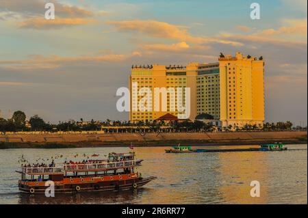 Ein Dinner-Kreuzfahrtschiff. Flussschifffahrt auf dem Tonle SAP River in der Dämmerung, das Sokha Hotel im Hintergrund, Phnom Penh, Kambodscha. Kredit: Kraig lieb Stockfoto