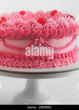 Rosafarbener, süßfroster Tassentorte mit italienischem englischem Schriftzeichen als Aufdruck für Bithday. Spaßiges Altern. Humorvolles Speisekonzept. Stockfoto