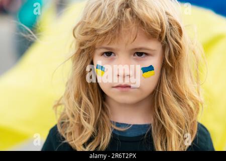 Ukraine Flagge auf Kinderbacken. Menschlicher Protest. Stockfoto