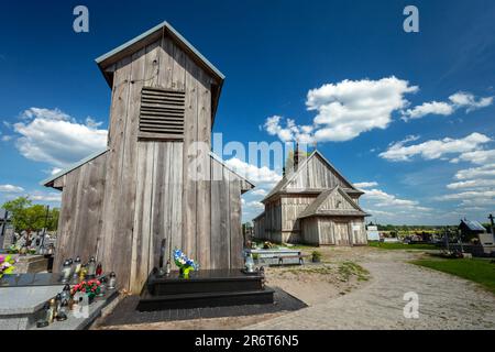 Przysiolek, Lubelskie, Polen - 14. Mai 2023: Historischer Glockenturm und hölzerne römisch-katholische Kirche ab 1746, Vorderansicht Stockfoto