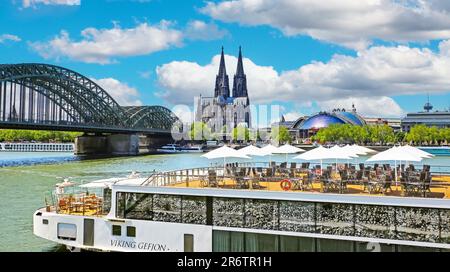 Köln (Köln), Deutschland - Juni 6. 2023 Uhr: Wunderschöne Skyline des rheins mit Dom, Hohenzollernbrücke und Terrasse des Kreuzfahrtschiffes Stockfoto