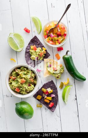 Ein Arrangement knuspriger Tortilla-Chips mit hausgemachter Guacamole und Salsa. Stockfoto