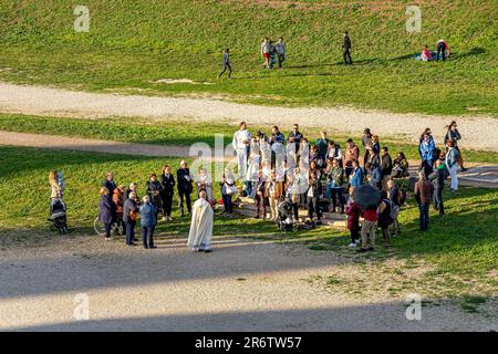 Eine kleine Menschenmenge besucht eine religiöse Versammlung im Circus Maximus, einer alten römischen Wagenrennbahn, Rom Italien Stockfoto