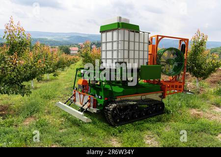 Die autonome Roboterspritze arbeitet in einem Obstgarten. Konzept der intelligenten Landwirtschaft Stockfoto