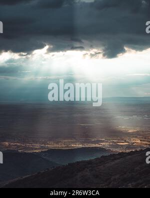 Eine atemberaubende Landschaft entfaltet sich, wenn sich die Wolken auflösen, sodass die Sonne in den Himmel eindringt. Das göttliche Spektakel der Natur enthüllt eine Szene von et Stockfoto