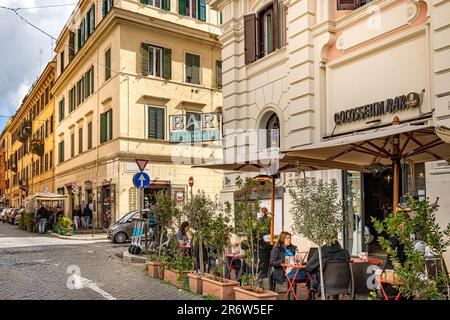 Gäste sitzen vor der Kolosseum Bar in Monti, einem schicken Viertel in der Nähe des Kolosseums in Rom, Italien Stockfoto