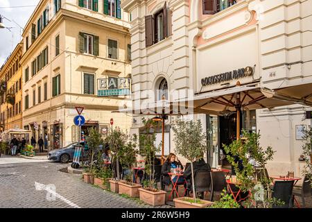 Gäste sitzen vor der Kolosseum Bar in Monti, einem schicken Viertel in der Nähe des Kolosseums in Rom, Italien Stockfoto