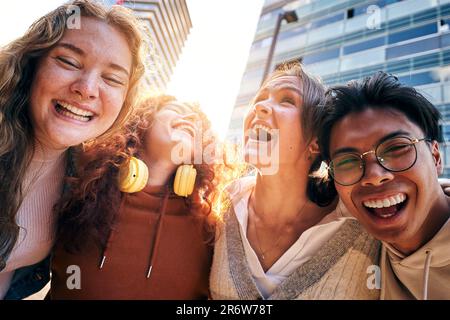 Selfie einer multirassischen Gruppe junger, glücklicher College-Studenten, die lachen. Vier Freunde, die lächelnd umarmten. Stockfoto