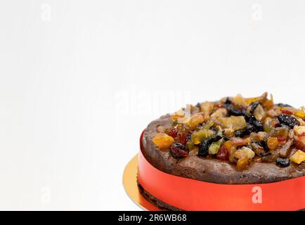 Nahaufnahme: Plum Cake oder Christmas Cake – trockenes Obst oben. Weißer Isolierter Hintergrund Stockfoto