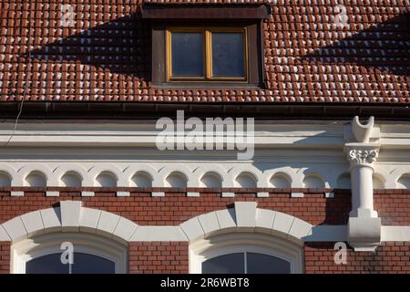 Ein kleiner Teil des Daches und die Fassade eines historischen neogotischen Gebäudes. Stockfoto