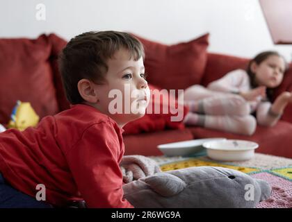 Singles, die sich im Wohnzimmer entspannen und Fernsehen Stockfoto