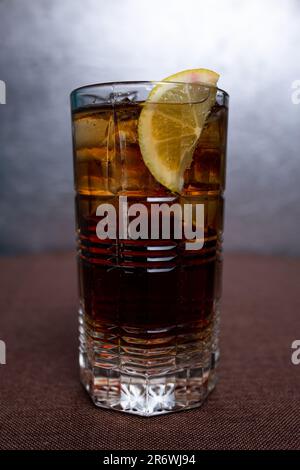 Kaltes kohlensäurehaltiges Erfrischungsgetränk mit Zitrone in einem Glas. Stockfoto