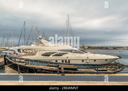 Die Yacht und ein altes Holzboot liegen auf demselben Pier des Cambrils Marina, Golden Coast, Provinz Tarragona, Katalonien, Spanien, Europa Stockfoto