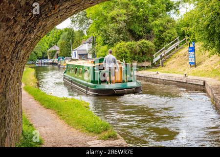 Kanal-Narrowboat durch das Dorf Govilon in Südwales am ruhigen Monmouth und Brecon Kanal Stockfoto