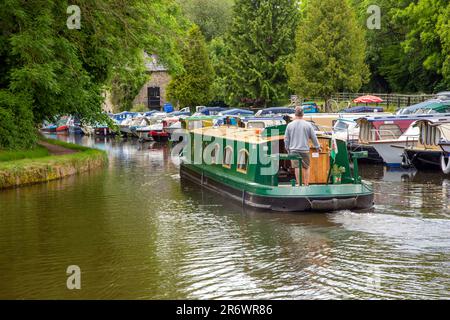 Kanal-Narrowboat durch das Dorf Govilon in Südwales am ruhigen Monmouth und Brecon Kanal Stockfoto