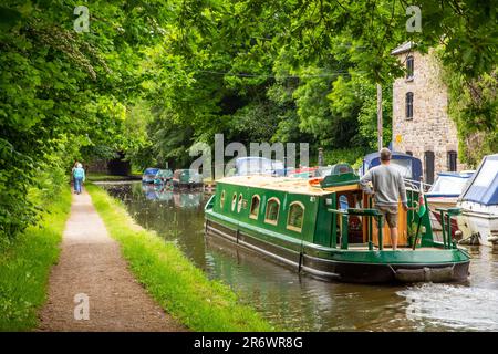 Kanal-Narrowboat durch das Dorf Govilon in Südwales am ruhigen Monmouth und Brecon Kanal Stockfoto