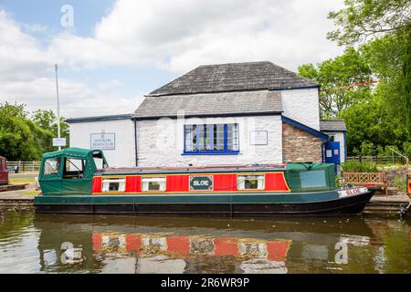 Kanal-Narrowboat durch das Dorf Govilon in Südwales am ruhigen Monmouth und Brecon Kanal Stockfoto