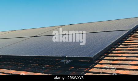 Sonnenkollektoren auf dem Dach, die während des trockenen Sommermonats mit Staub bedeckt sind. Stockfoto