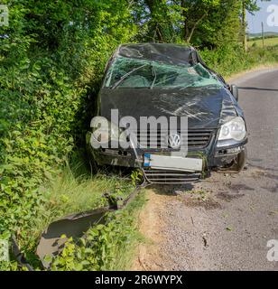 Schwer beschädigter VW Golf nach Absturz am Straßenrand. Stockfoto