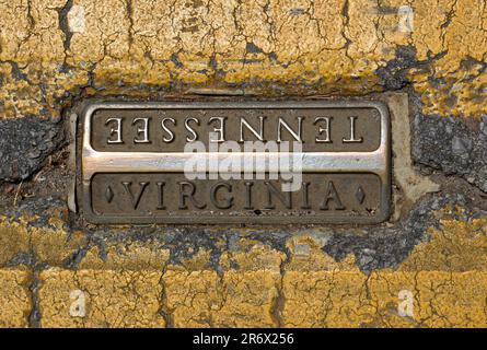 Eine Metallmarkierung, die in der Mitte der State Street in Bristol, Virginia, und Bristol, Tennessee, eingebettet ist und die Grenze zwischen Virginia und Tennessee anzeigt Stockfoto