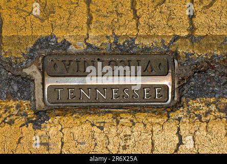 Eine Metallmarkierung, die in der Mitte der State Street in Bristol, Virginia, und Bristol, Tennessee, eingebettet ist und die Grenze zwischen Virginia und Tennessee anzeigt Stockfoto