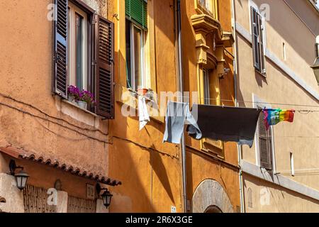 Die Wäsche hängt an einer Wäscheleine, die zwischen den Gebäuden auf dem Vicolo del Cedro in Trestevere, Rom, Italien hängt Stockfoto