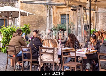Leute sitzen an Tischen vor einem Trastevere Restaurant, Rom, Italien Stockfoto