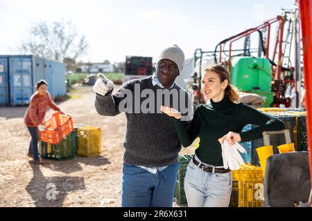 Mann und Frau Landarbeiter diskutieren Arbeit im Freien Stockfoto