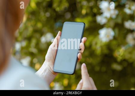 Nahaufnahme einer Frau in der Stadt mit Smartphone-App. Stockfoto