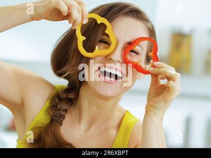 Lustige junge Frau, die Scheiben Paprika Stockfoto