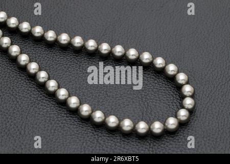 Elegante schwarze Perlenkette auf schwarzem Hintergrund Stockfoto