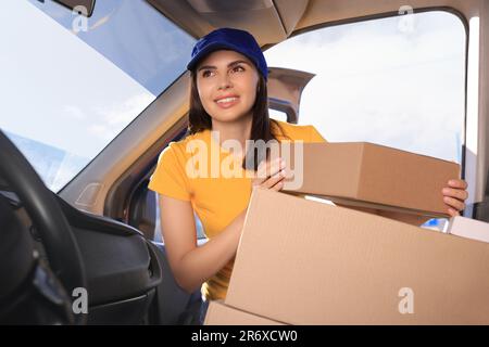 Der Kurier nimmt das Paket vom Auto ab. Lieferservice Stockfoto