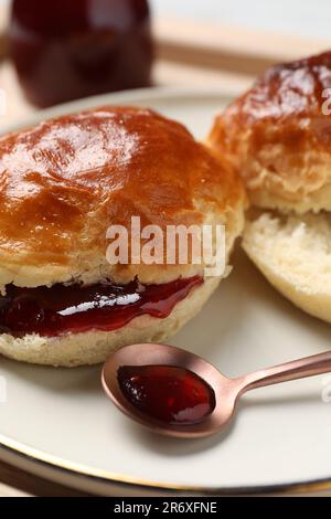 Frisch gebackene Soda-Wasser-Scones mit Preiselbeermarmelade auf Holztisch, Nahaufnahme Stockfoto