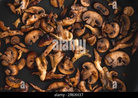 Brawned Wild Mushroom s Nahaufnahme in einer antihaftbeschichteten Sautenpfanne von oben: Blick von oben auf Austern, Shiitake und Krimini-Pilze in Butter gekocht Stockfoto