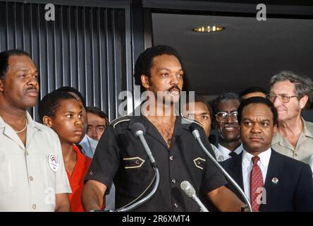 DULLES, VIRGINIA - 28. JUNI 1984 der Reverend Jesse Jackson, flankiert von DC-Bürgermeister Marion Barry (L) und Delegat Walter Faunroy (D-DC) (R), der kurz nach seiner Landung auf seiner Rückkehr aus Havanna auf einer Pressekonferenz im Dulles International Airport sprach, Kuba mit befreiten amerikanischen und kubanischen Gefangenen sagte, dass er überzeugt sei, dass Frieden in Mittelamerika möglich sei. Stockfoto