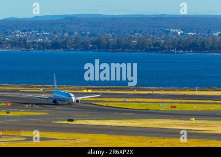 Ein Flugzeug auf der Runway 16R/34L am Sydney Airport in Sydney, Australien. Abbildung: Ein Virgin Australia Jet, der zum Inlandsterminal fährt. Stockfoto