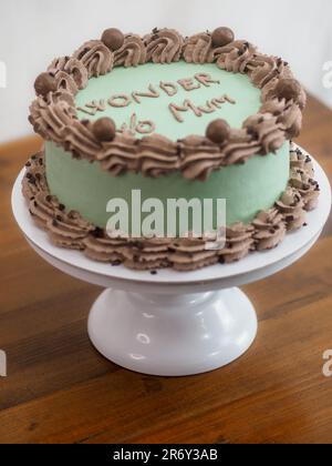 Eleganter Milchglaskuchen mit lustigen Schriftzügen. Muttertag-Feier-Cupcake. Humor im Lebensmittelkonzept. Familienliebe. Stockfoto