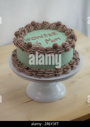 Eleganter Milchglaskuchen mit lustigen Schriftzügen. Muttertag-Feier-Cupcake. Humor im Lebensmittelkonzept. Familienliebe. Stockfoto