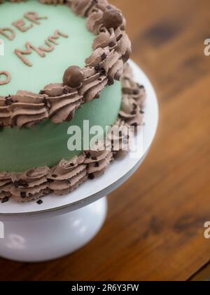 Eleganter Milchglaskuchen mit lustigen Schriftzügen. Muttertag-Feier-Cupcake. Humor im Lebensmittelkonzept. Familienliebe. Stockfoto