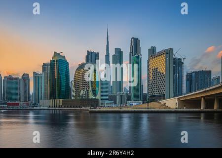 Blick auf das Geschäfts- und Finanzzentrum von Dubai in den Vereinigten Arabischen Emiraten. Wolkenkratzer am Abend bei Sonnenuntergang. Sonnenlichtreflexion auf dem Glas Stockfoto