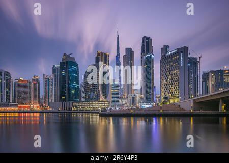 Blue Hour in Dubai. Lange Exposition am Abend nach Sonnenuntergang. Blick auf die Skyline der Innenstadt in den Vereinigten Arabischen Emiraten. Beleuchtetes Geschäftsgebäude Stockfoto