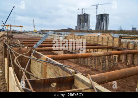 Ein riesiger Gräben-Tunnel mit Verstärkungsstrukturen aus dicken Eisenrohren und Bauten auf der Baustelle des unterirdischen Me Stockfoto