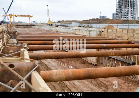 Ein riesiger Gräben-Tunnel mit Verstärkungsstrukturen aus dicken Eisenrohren und Bauten auf der Baustelle des unterirdischen Me Stockfoto