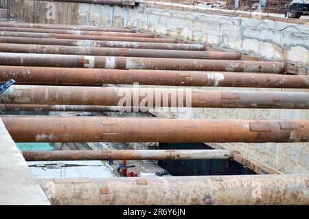 Ein riesiger Gräben-Tunnel mit Verstärkungsstrukturen aus dicken Eisenrohren und Bauten auf der Baustelle des unterirdischen Me Stockfoto