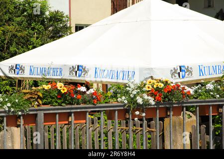 Ein Kulmbacher-Biersonnenschirm in einem Biergarten in Franken - Deutschland, Mai 28 2023 Stockfoto