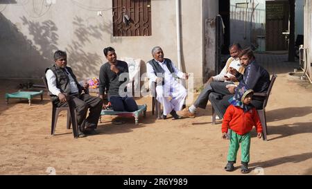 08. Juni 2023 Jaipur, Rajasthan, Indien. Indianer sitzen draußen in der Gruppe. Sie kamen hierher, um an einem Kommunionsbankett teilzunehmen. Stockfoto